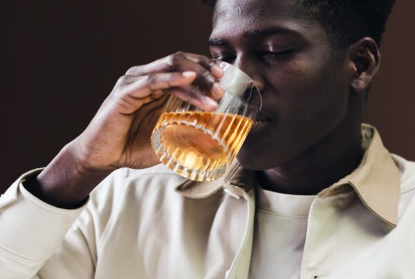 close up shot of a man drinking a glass of liquor